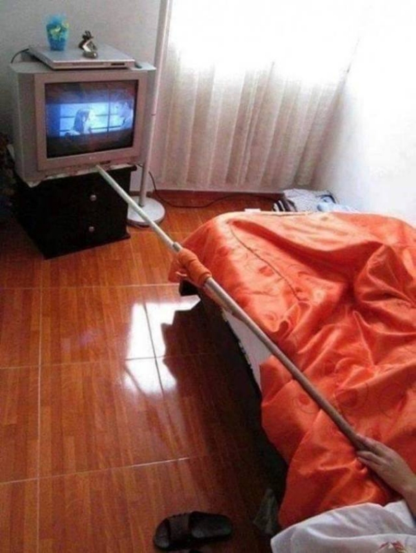 Im Bett faulenzen. Beim Fernseher Kanal umstellen und dabei liegen bleiben