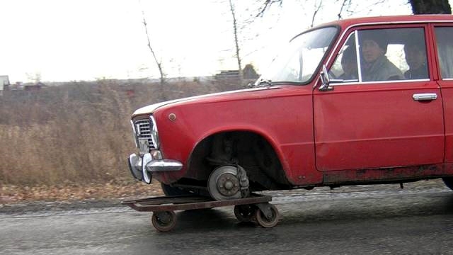Schrottfreifes Auto mit drei Reifen Menschliche Marotten: Lustige Geschichten aus dem Leben Schrottreifes Auto mit drei Reifen. Lustige Osteuropäischen Fahrzeuge