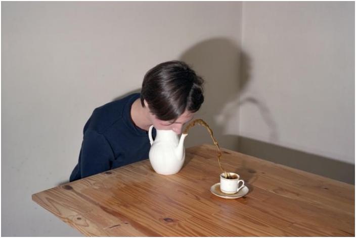 Ausgefallene Art Kaffee einzuschenken. Lustig in die Kaffeekanne pusten