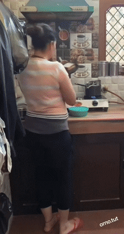 Witziges Ehepaar. Frau macht sich Essen und der Mann stiehlt es