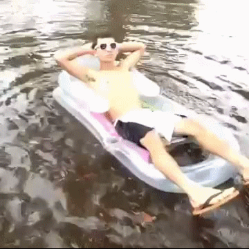 Gute Laune bei schlechtem Wetter. Lustig auf der Luftmatratze in der Pfütze liegen.